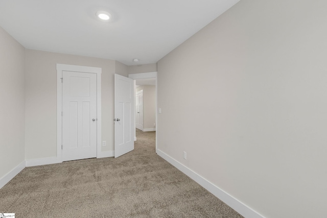 unfurnished bedroom with light carpet and a closet