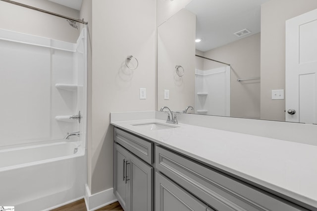 bathroom with hardwood / wood-style floors, vanity, and shower / washtub combination