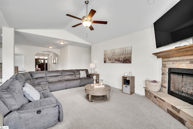 living room featuring a fireplace, carpet flooring, vaulted ceiling, and ceiling fan