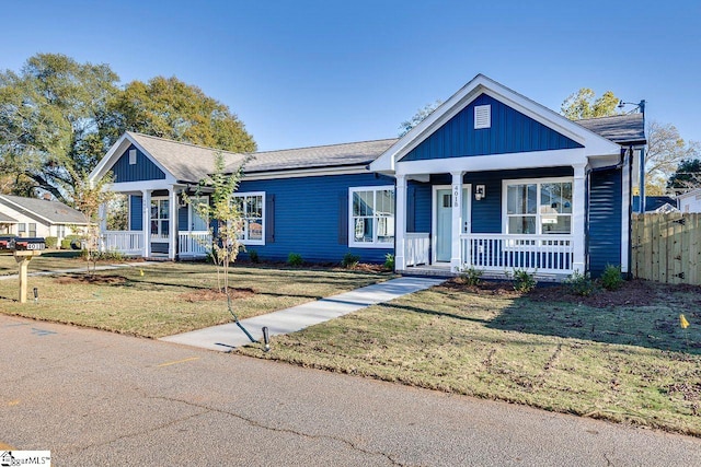 view of front of property with a porch and a front lawn