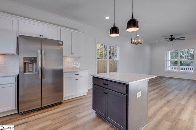 kitchen with white cabinets, stainless steel fridge with ice dispenser, and a healthy amount of sunlight