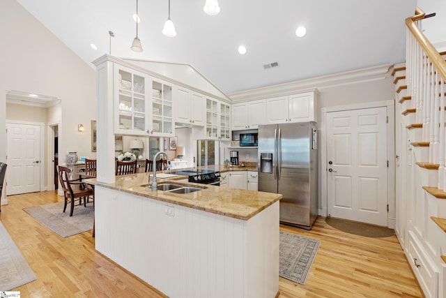 kitchen featuring white cabinets, stainless steel refrigerator with ice dispenser, light stone countertops, decorative light fixtures, and light hardwood / wood-style floors