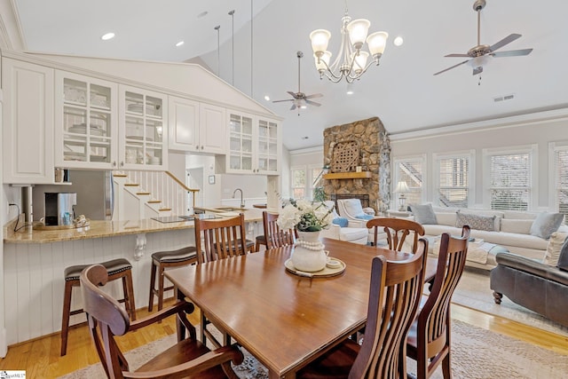 dining area featuring ceiling fan with notable chandelier, light hardwood / wood-style floors, and a wealth of natural light