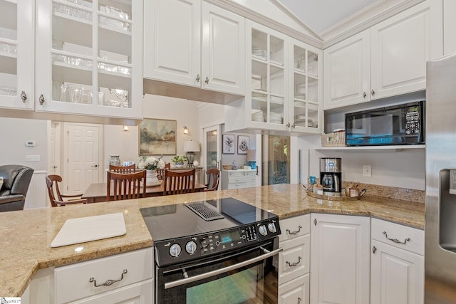 kitchen with black appliances, white cabinets, light stone counters, and vaulted ceiling