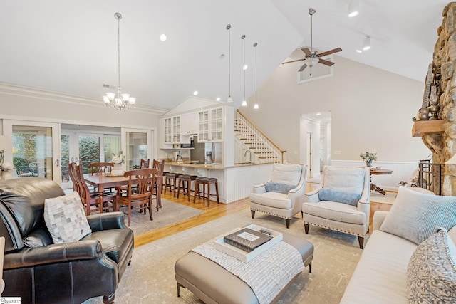 living room featuring ornamental molding, ceiling fan with notable chandelier, sink, high vaulted ceiling, and light hardwood / wood-style flooring