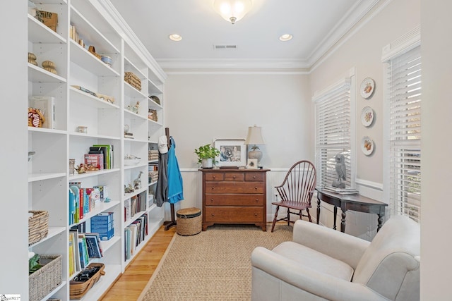 sitting room featuring light wood-type flooring and crown molding