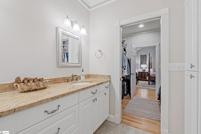 bathroom featuring crown molding, vanity, and wood-type flooring