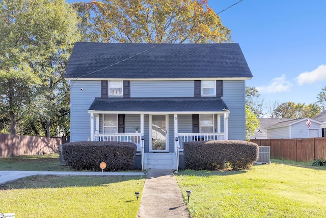 view of front facade featuring central AC, covered porch, and a front yard