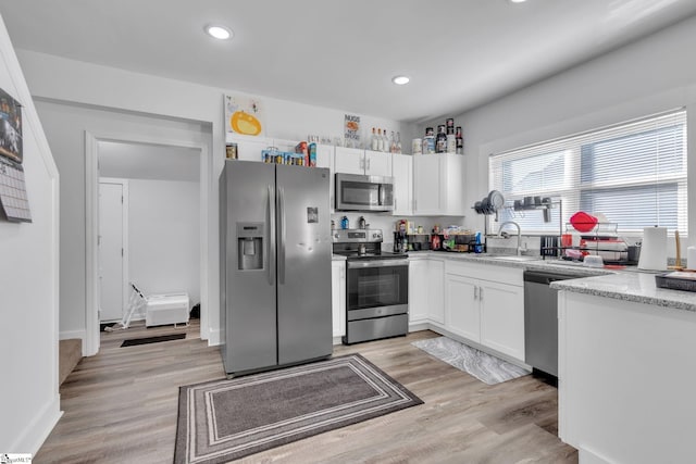 kitchen featuring white cabinets, light hardwood / wood-style floors, sink, and appliances with stainless steel finishes