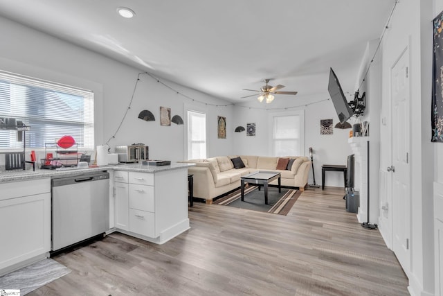 kitchen featuring a healthy amount of sunlight, white cabinetry, stainless steel dishwasher, and light wood-type flooring