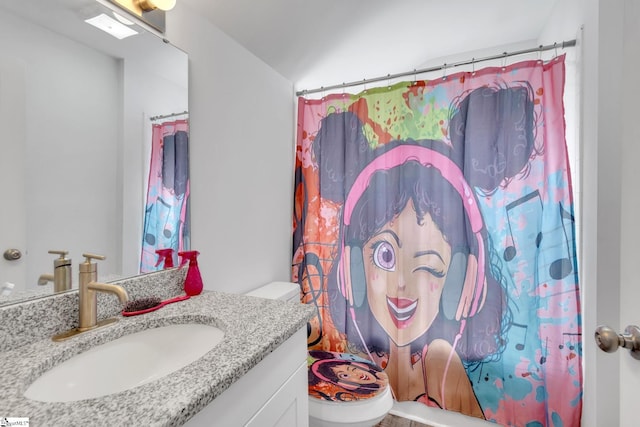 bathroom with vanity, a shower with shower curtain, and toilet