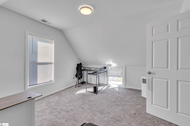 workout room featuring light colored carpet and vaulted ceiling