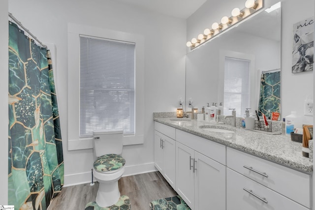 bathroom featuring hardwood / wood-style floors, vanity, a healthy amount of sunlight, and toilet