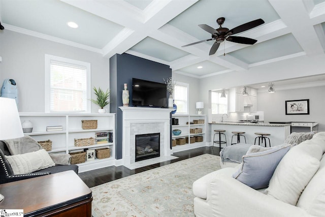 living room featuring beamed ceiling, crown molding, dark wood-type flooring, and coffered ceiling