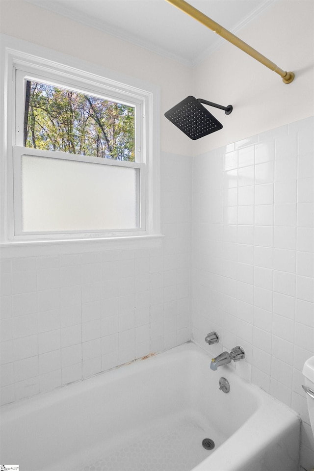 bathroom featuring toilet, a healthy amount of sunlight, tiled shower / bath combo, and ornamental molding