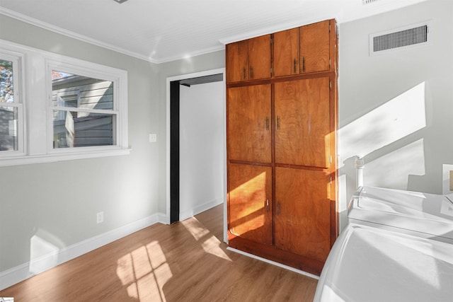 interior space with crown molding and light hardwood / wood-style floors