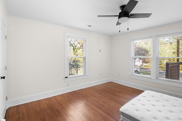 bedroom with hardwood / wood-style flooring, ceiling fan, and crown molding