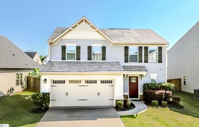 view of front of property with central AC unit, a garage, and a front yard