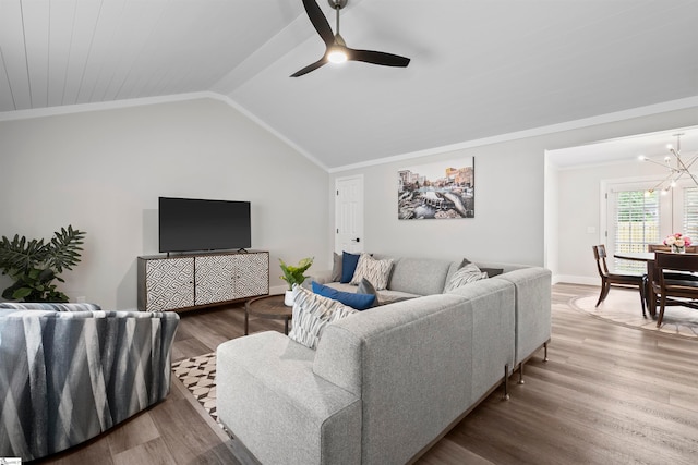 living room featuring wood-type flooring, ceiling fan with notable chandelier, vaulted ceiling, and crown molding