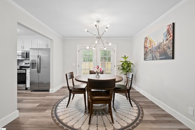 dining area with light hardwood / wood-style flooring, ornamental molding, and a notable chandelier