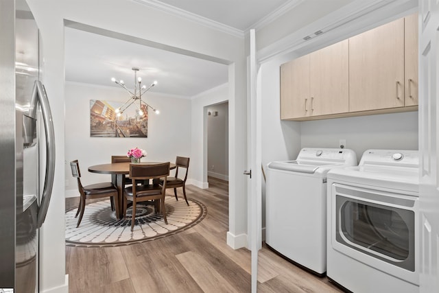 washroom with washer and clothes dryer, cabinets, ornamental molding, light hardwood / wood-style floors, and a chandelier