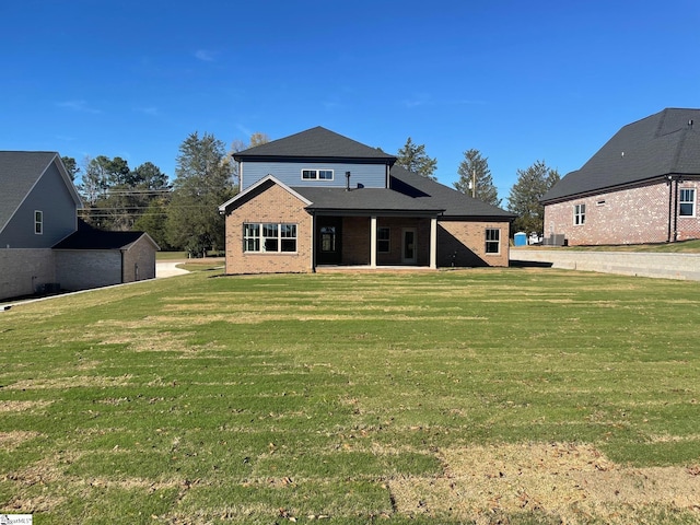 rear view of property featuring a lawn