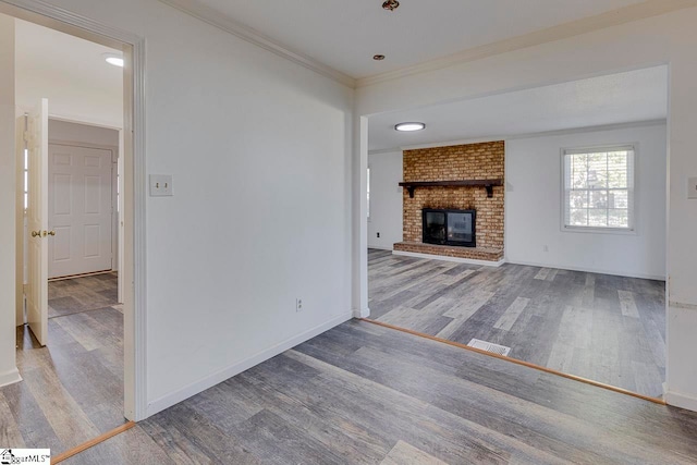 unfurnished living room with crown molding, a fireplace, and hardwood / wood-style flooring