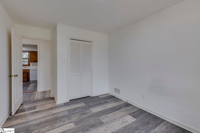 unfurnished bedroom with hardwood / wood-style floors and a closet