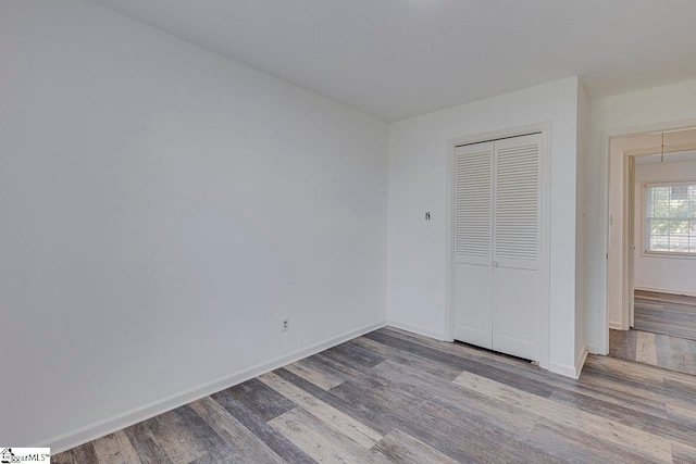 unfurnished bedroom featuring wood-type flooring and a closet