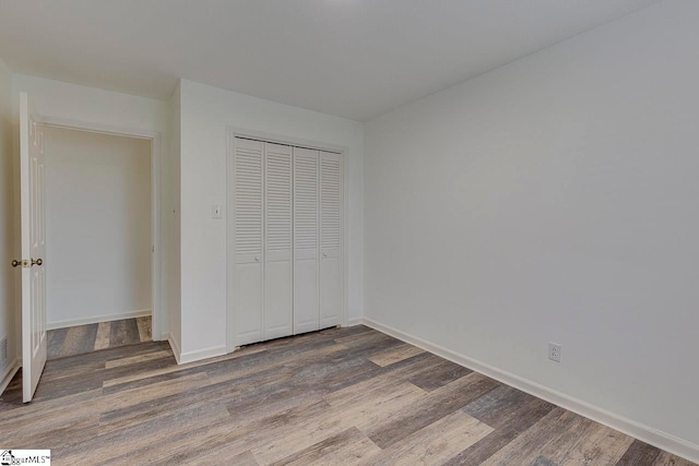 unfurnished bedroom featuring a closet and dark wood-type flooring