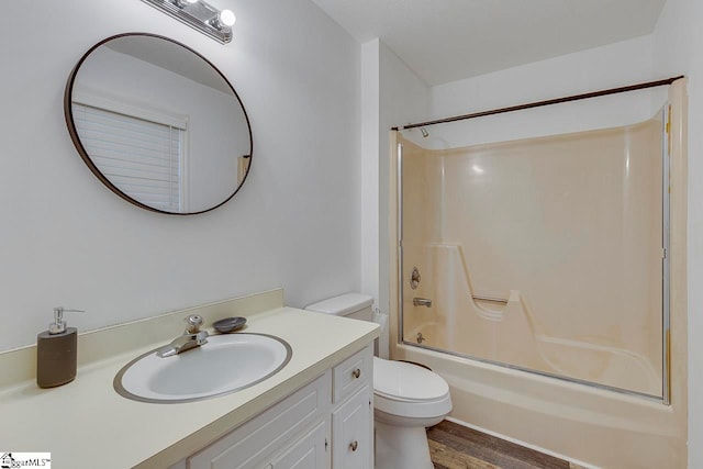 full bathroom with shower / bath combination with glass door, vanity, hardwood / wood-style flooring, and toilet