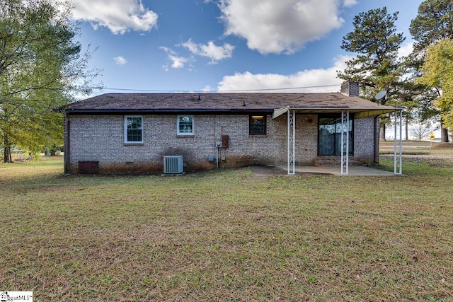 rear view of property featuring a yard, central AC unit, and a patio area