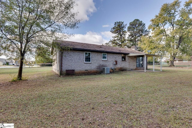 rear view of property with a lawn and central air condition unit