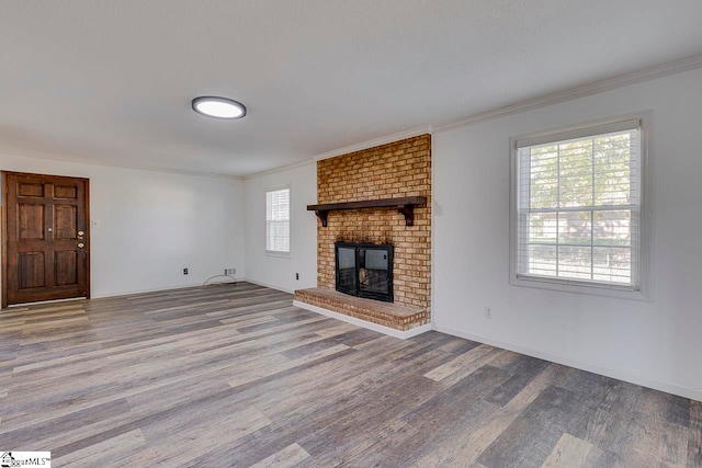 unfurnished living room featuring a fireplace, hardwood / wood-style flooring, and ornamental molding