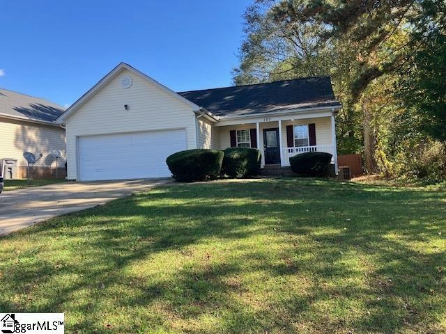 ranch-style home with covered porch, central air condition unit, a garage, and a front yard