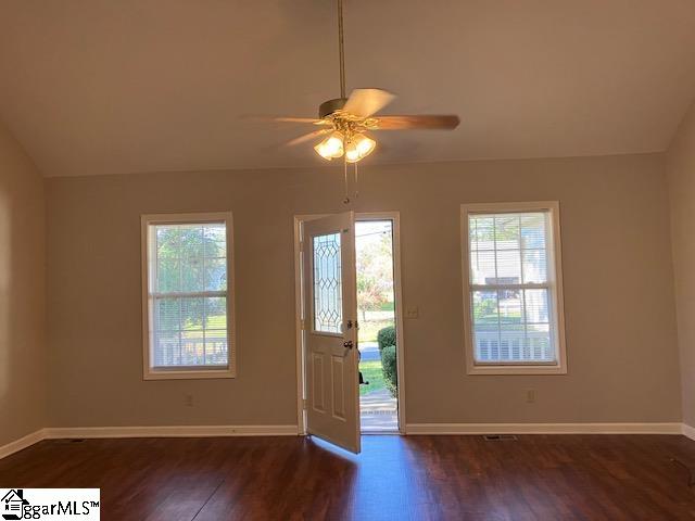 foyer entrance featuring ceiling fan, dark wood-type flooring, and vaulted ceiling