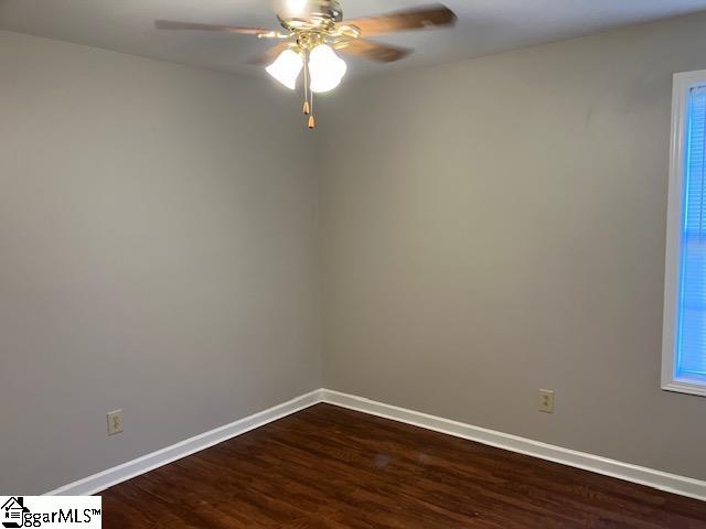 unfurnished room featuring dark hardwood / wood-style flooring and ceiling fan