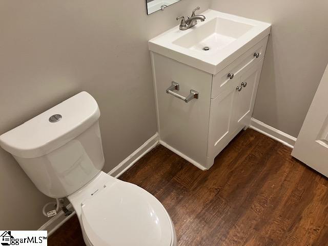 bathroom with hardwood / wood-style flooring, vanity, and toilet