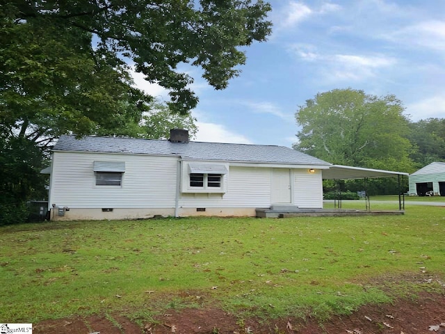 view of side of property featuring a carport and a yard