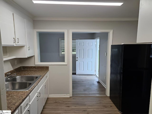 kitchen with white cabinetry, black refrigerator, dark hardwood / wood-style floors, and sink