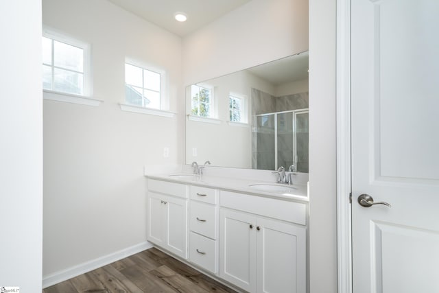 bathroom featuring walk in shower, wood-type flooring, and vanity