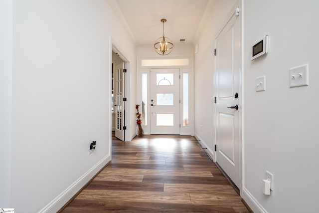 doorway featuring dark hardwood / wood-style flooring and a notable chandelier