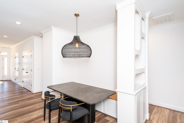 dining room with breakfast area, dark hardwood / wood-style floors, and ornamental molding