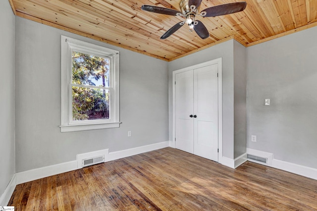 unfurnished bedroom with hardwood / wood-style flooring, ceiling fan, ornamental molding, wood ceiling, and a closet