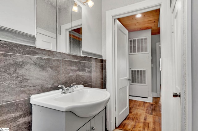 bathroom featuring hardwood / wood-style flooring, vanity, and tile walls