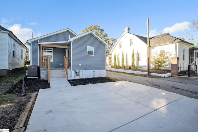 back of house with covered porch and central AC