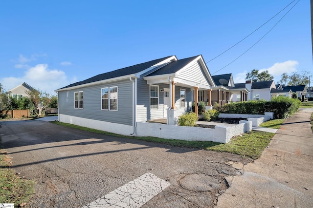 view of side of home featuring covered porch