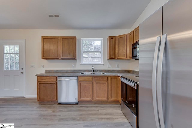 kitchen featuring sink, stainless steel appliances, plenty of natural light, and light hardwood / wood-style floors