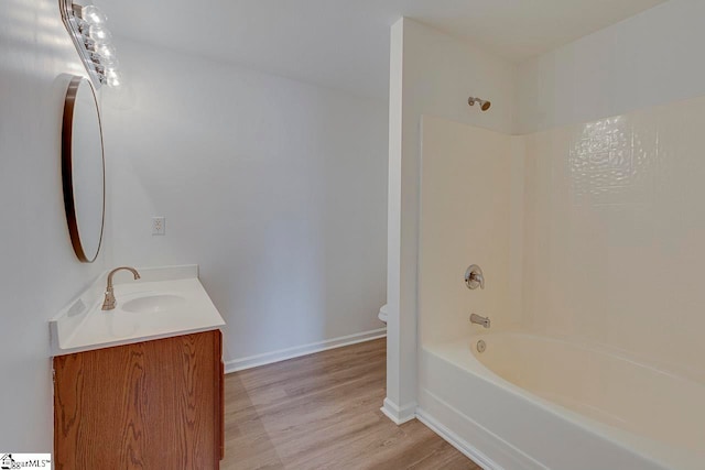 full bathroom featuring hardwood / wood-style floors, vanity, toilet, and bathing tub / shower combination