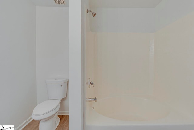 bathroom featuring toilet, tub / shower combination, and hardwood / wood-style flooring